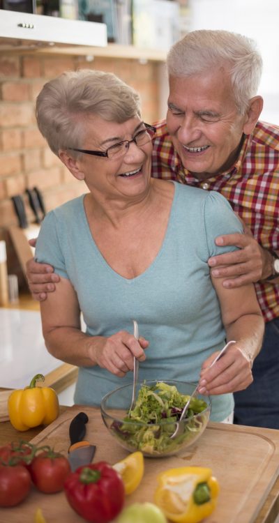 Senior couple preparing fresh salad together